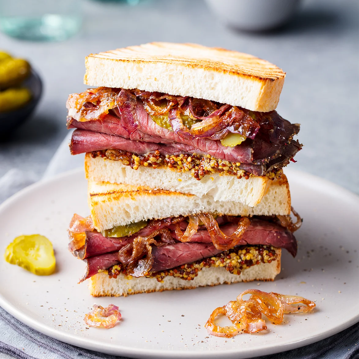 Hamburguesa gourmet con queso fundido, bacon crujiente y rúcula sobre pan brioche.